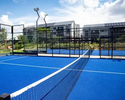 a tennis court with a net in front of a building at Cityescapes 2F in Waterfall Midrand - Beautiful self catering 2 bedroom unit next to Kyalami Racetrack with free WiFi swimming pool gym and restaurant - Perfect for a small family in Midrand