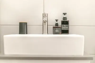 a white sink with two bottles on top of it at Cityescapes 2F in Waterfall Midrand - Beautiful self catering 2 bedroom unit next to Kyalami Racetrack with free WiFi swimming pool gym and restaurant - Perfect for a small family in Midrand
