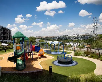 a playground with three slides at Cityescapes 2F in Waterfall Midrand - Beautiful self catering 2 bedroom unit next to Kyalami Racetrack with free WiFi swimming pool gym and restaurant - Perfect for a small family in Midrand