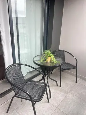 three chairs and a table with a potted plant on it at Stylish Waterfall Apartment -Braai ,Fast WiFi, Pool in Midrand