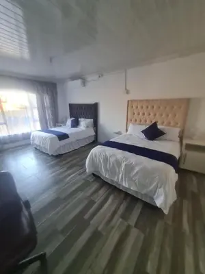 a bedroom with two beds and a large window at Divine villa in Louis Trichardt
