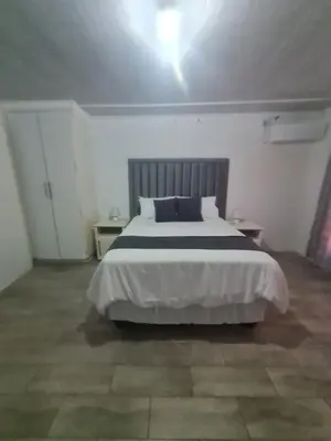 a bedroom with a large bed in a white room at Divine villa in Louis Trichardt