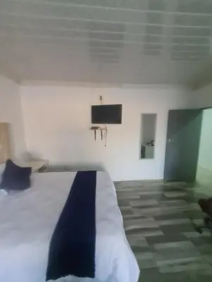 a bedroom with a bed and a tv on the wall at Divine villa in Louis Trichardt