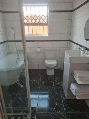 a bathroom with a tub and a toilet and a sink at Divine villa in Louis Trichardt