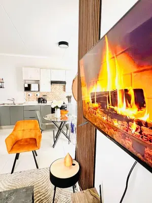 a living room with a fireplace in the wall at Classy 1 bed in Midrand at 93 on New Estate in Midrand