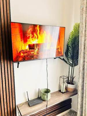 a tv hanging on a wall with a fireplace at Classy 1 bed in Midrand at 93 on New Estate in Midrand