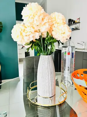 a white vase with pink flowers on a table at Classy 1 bed in Midrand at 93 on New Estate in Midrand