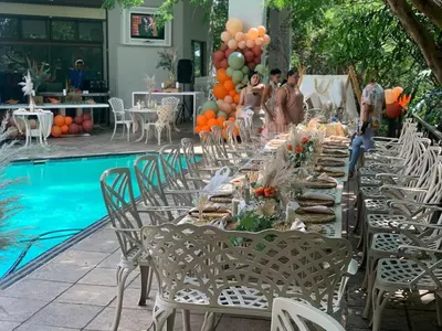 a table set up for a party by a pool at The Palace Guest House in Pretoria