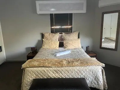a bedroom with a bed and a mirror at The Palace Guest House in Pretoria