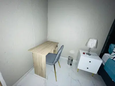 a room with a desk and a chair next to a bed at Cottage tranquility in Pretoria
