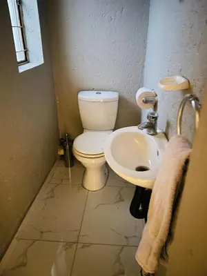 a bathroom with a toilet and a sink at Cottage tranquility in Pretoria