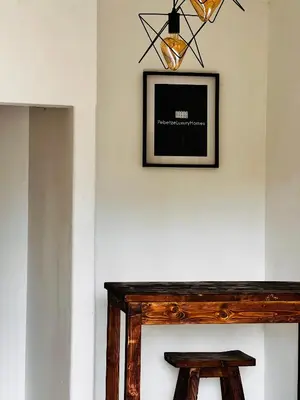 a picture hanging above a fireplace with a wooden table at PebetseLuxury Holiday home in Kempton Park