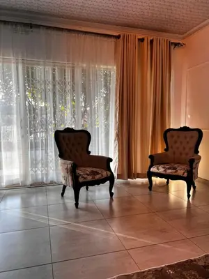 two chairs sitting in front of a large window at PebetseLuxury Holiday home in Kempton Park