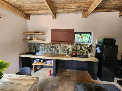 a kitchen with a table and a refrigerator at Hartbeest Bush Stay #6 in Hartbeespoort