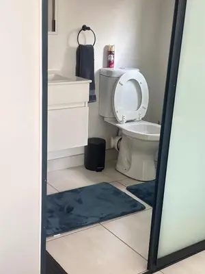 a bathroom with a toilet and a blue rug at Three bedrooms Apartment at The Blyde Lagoons PTA in Pretoria