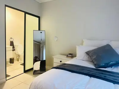 a bedroom with a large bed and a mirror at Three bedrooms Apartment at The Blyde Lagoons PTA in Pretoria