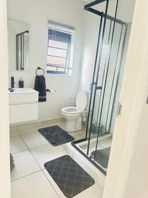 a bathroom with a shower and a toilet and a sink at Three bedrooms Apartment at The Blyde Lagoons PTA in Pretoria