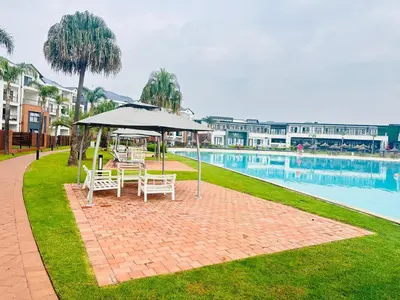a table and chairs with an umbrella next to a pool at Three bedrooms Apartment at The Blyde Lagoons PTA in Pretoria