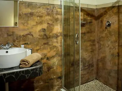 a bathroom with a shower and a sink at The Red Oak Guesthouse in Tzaneen