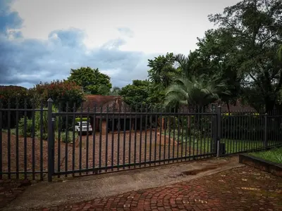 a black iron fence in front of a house at The Red Oak Guesthouse in Tzaneen