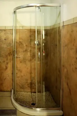 a shower with a glass door in a bathroom at The Red Oak Guesthouse in Tzaneen