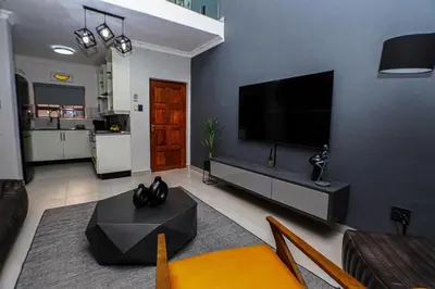 a living room with a flat screen tv on a wall at Luxe Living in Nelspruit