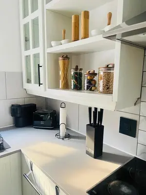 a kitchen with white cabinets and a counter with utensils at Luxe Living in Nelspruit