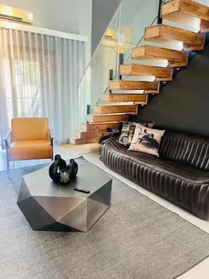 a living room with a couch and a staircase at Luxe Living in Nelspruit