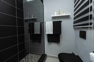 a bathroom with a shower with a toilet and towels at Luxe Living in Nelspruit