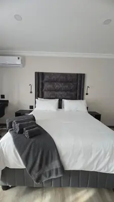 a bedroom with a large white bed with two pillows at Lavender Lofts in Centurion