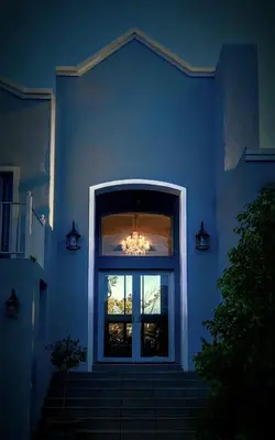 a blue house with a window and a chandelier at Belle Vie Boutique Guesthouse in Pretoria