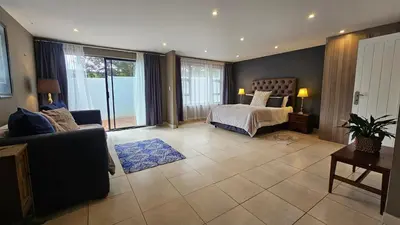 a bedroom with a bed and a couch in a room at Belle Vie Boutique Guesthouse in Pretoria