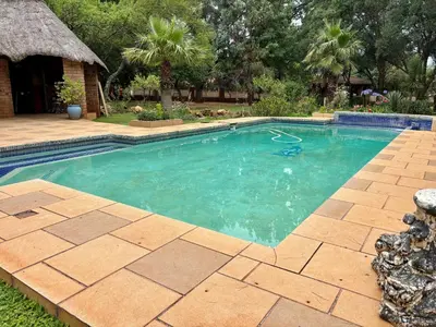 a swimming pool in a yard with a brick patio at Pazuri Homestay in Kempton Park