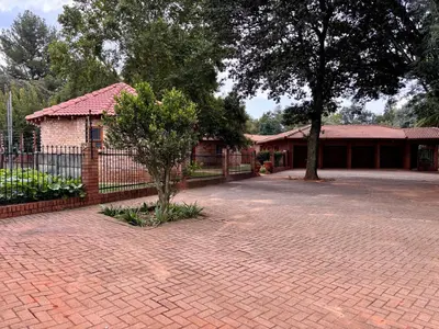 a brick driveway in front of a house with a fence at Pazuri Homestay in Kempton Park
