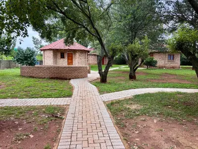 a brick path in a park with a building at Pazuri Homestay in Kempton Park