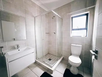 a bathroom with a shower and a toilet and a sink at Luxurious 1-Bedroom Apartment at The Blyde, Pretoria in Pretoria