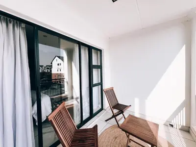 two chairs sitting on the balcony of a house at Luxurious 1-Bedroom Apartment at The Blyde, Pretoria in Pretoria
