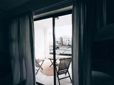 a room with a balcony with two chairs and a table at Luxurious 1-Bedroom Apartment at The Blyde, Pretoria in Pretoria