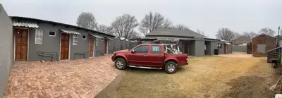 a red truck parked in front of a house at Relax Guest House in Ermelo