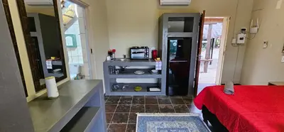a room with a bed and a kitchen with a microwave at The Rondawel in Marloth Park