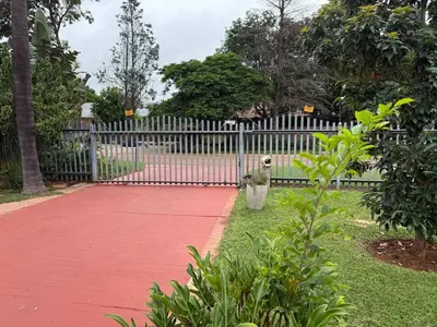 a dog standing in front of a fence at Flora Haven in Polokwane