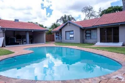 a swimming pool in front of a house at Flora Haven in Polokwane