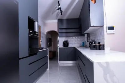 a kitchen with black cabinets and white counter tops at Flora Haven in Polokwane