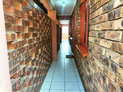 a hallway with a brick wall and a bench at KILIMANJARO Guest House in Middelburg