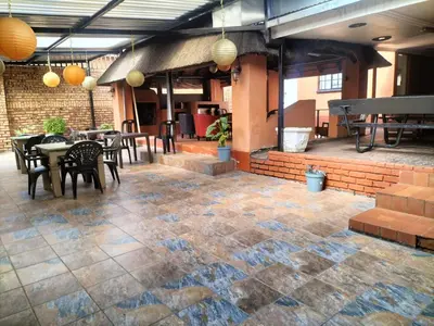a patio with tables and chairs in a building at KILIMANJARO Guest House in Middelburg