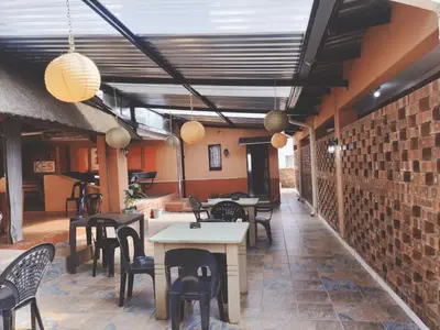a restaurant with tables and chairs and a brick wall at KILIMANJARO Guest House in Middelburg
