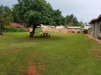 a picnic table under a tree in a yard at Royal guest lodge in Middelburg