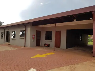 an empty building with a yellow arrow on a brick parking lot at Royal guest lodge in Middelburg