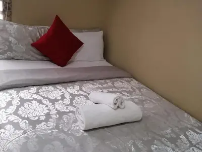 a bedroom with a bed with a towel on it at Royal guest lodge in Middelburg
