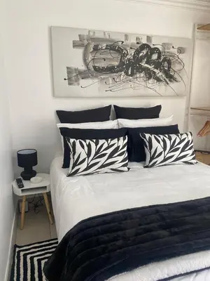 a bedroom with a bed with black and white pillows at Sleep on 489 in Pretoria